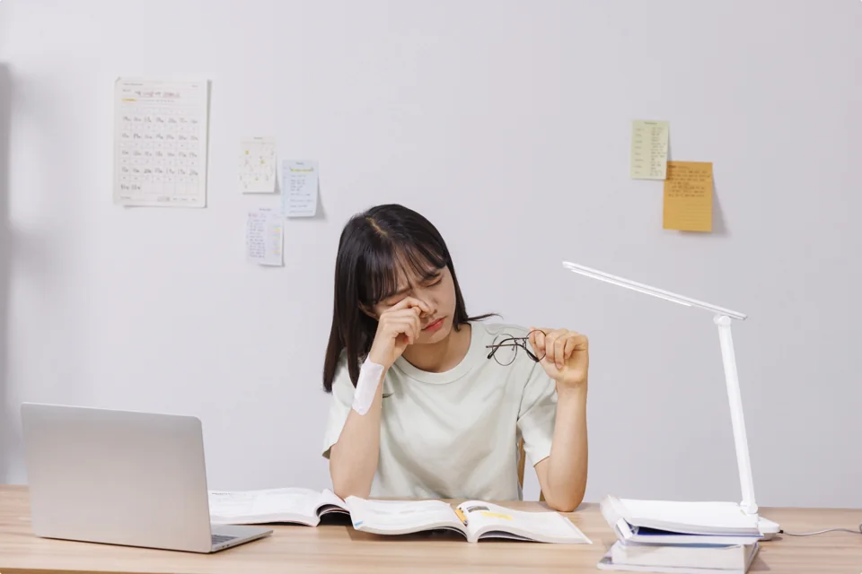책상에서 공책에 쓰는 학생