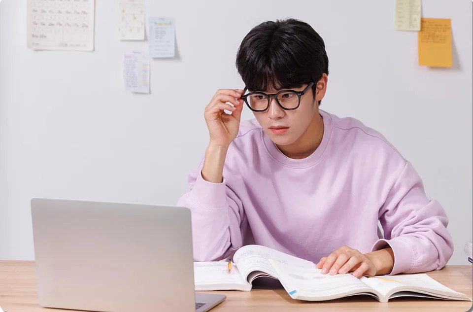 교재 앞에서 생각하는 학생
