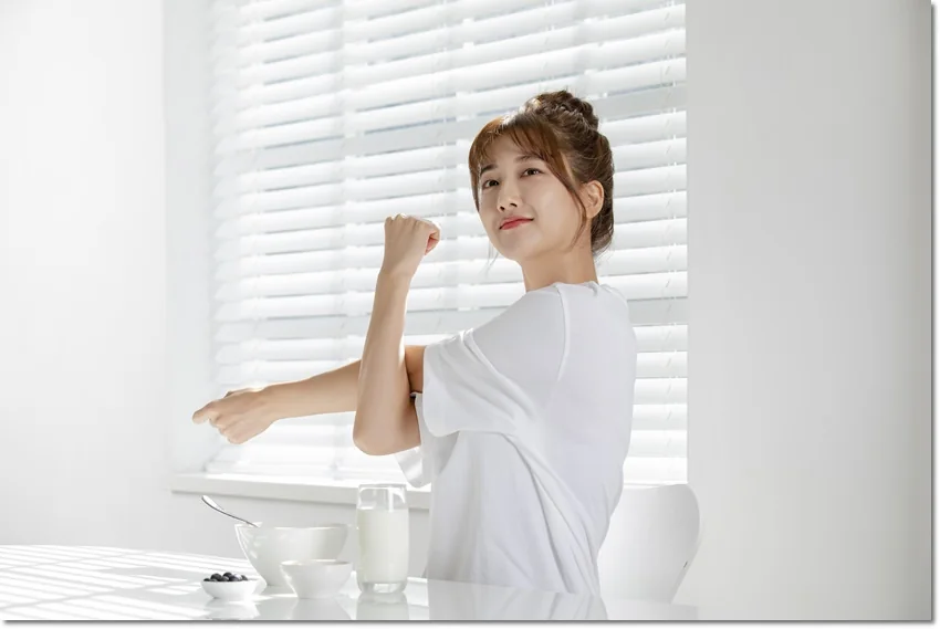 책상 앞에서 손을 들어 보이는 모습