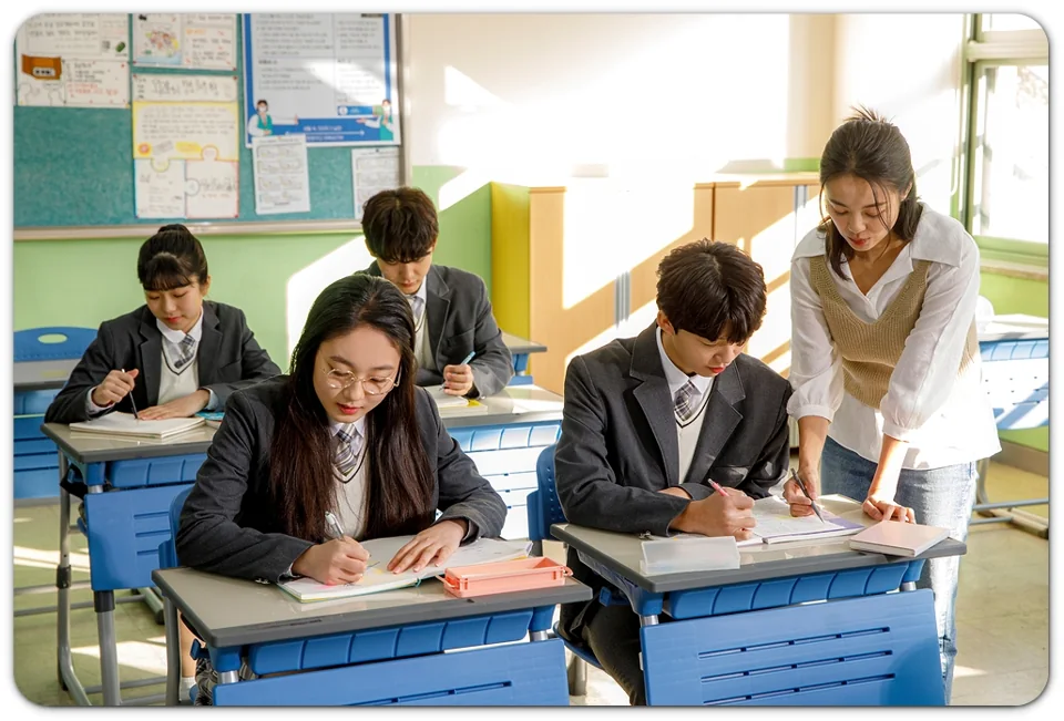 교실에서 학생의 교재를 살펴보는 모습