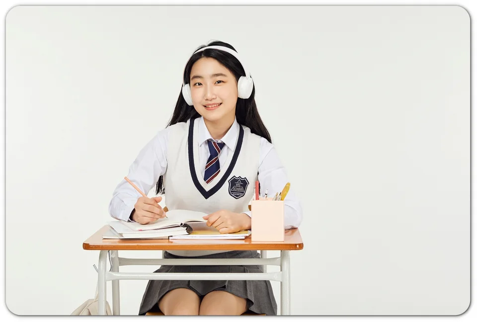 책상에서 헤드폰을 쓰고 공부하는 학생