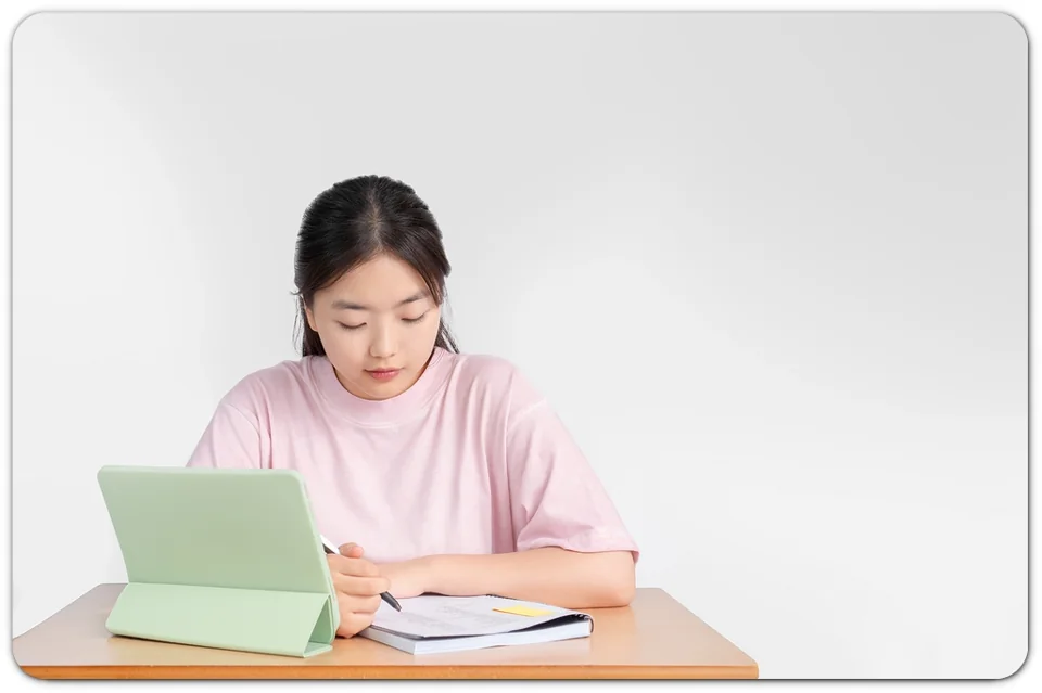 태블릿과 책으로 공부하는 학생