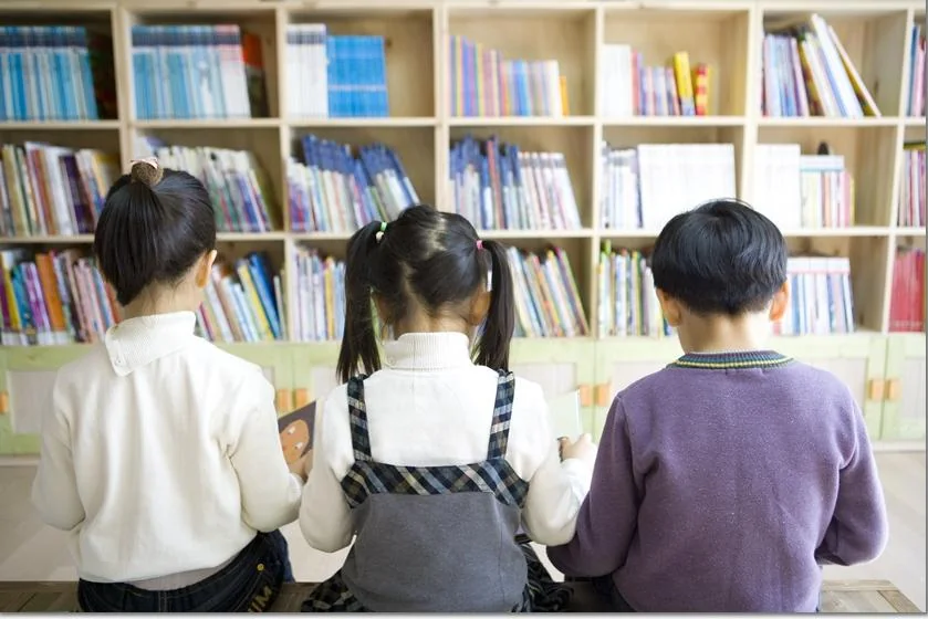 도서관 서가에서 책을 살펴보는 학생들