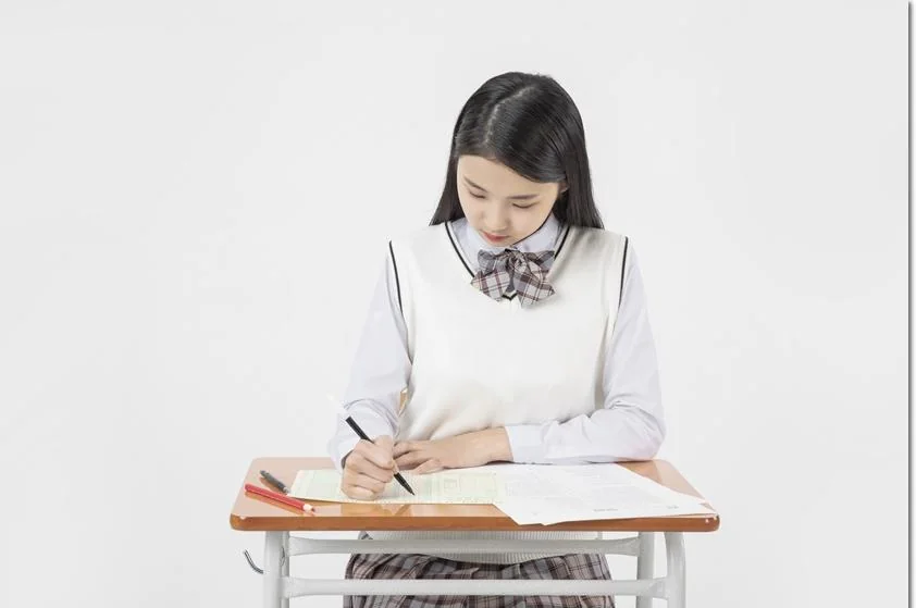 학교 책상에서 필기하는 학생