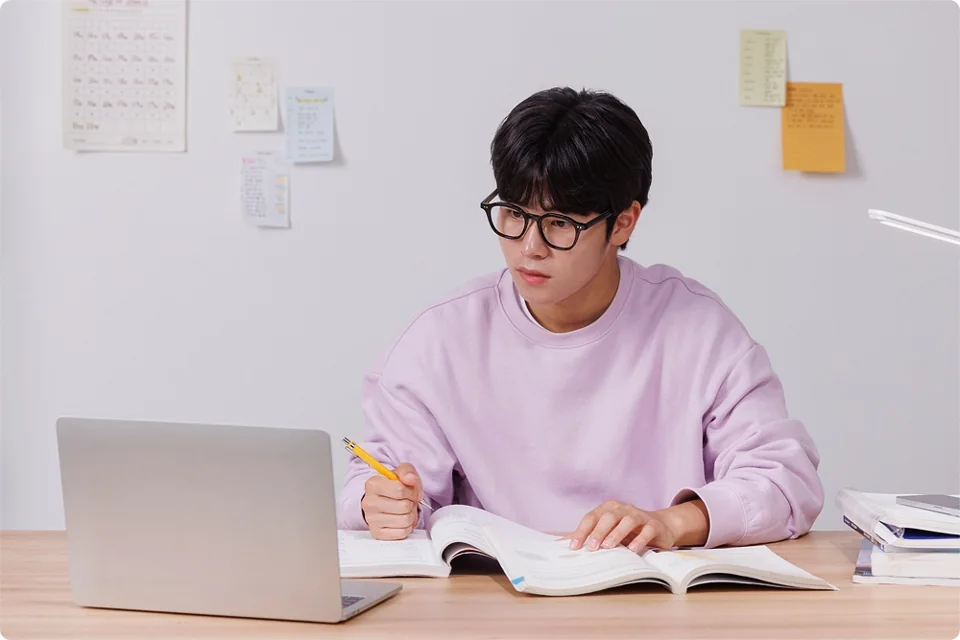 노트북과 교재를 앞에 둔 학생